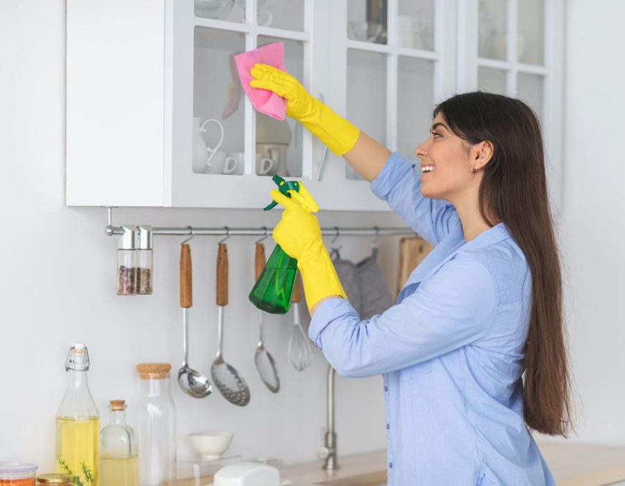 young-woman-cleaning-shelfs-at-home-at-kitchen